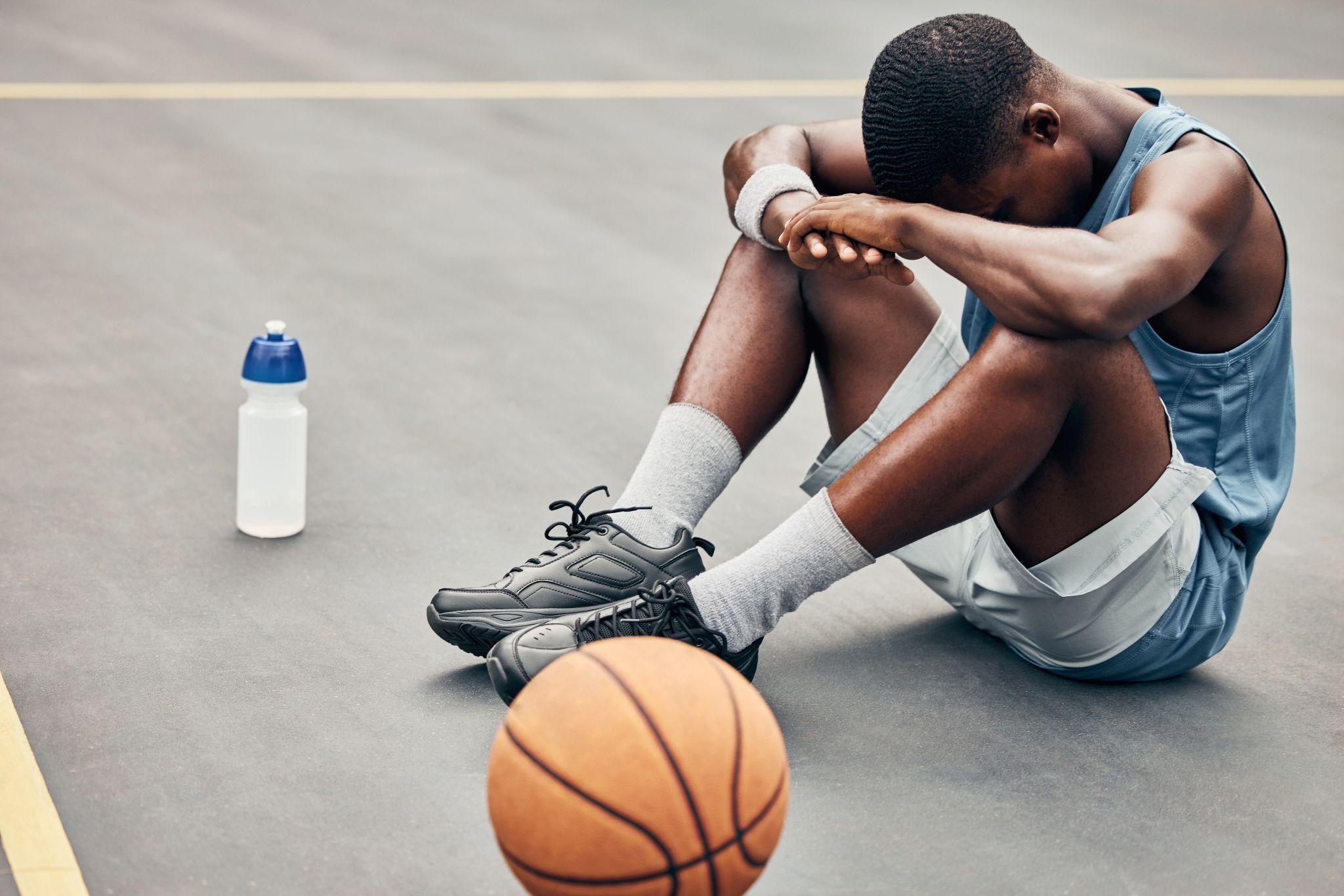 Tired, depression or sad basketball player with training gear after game