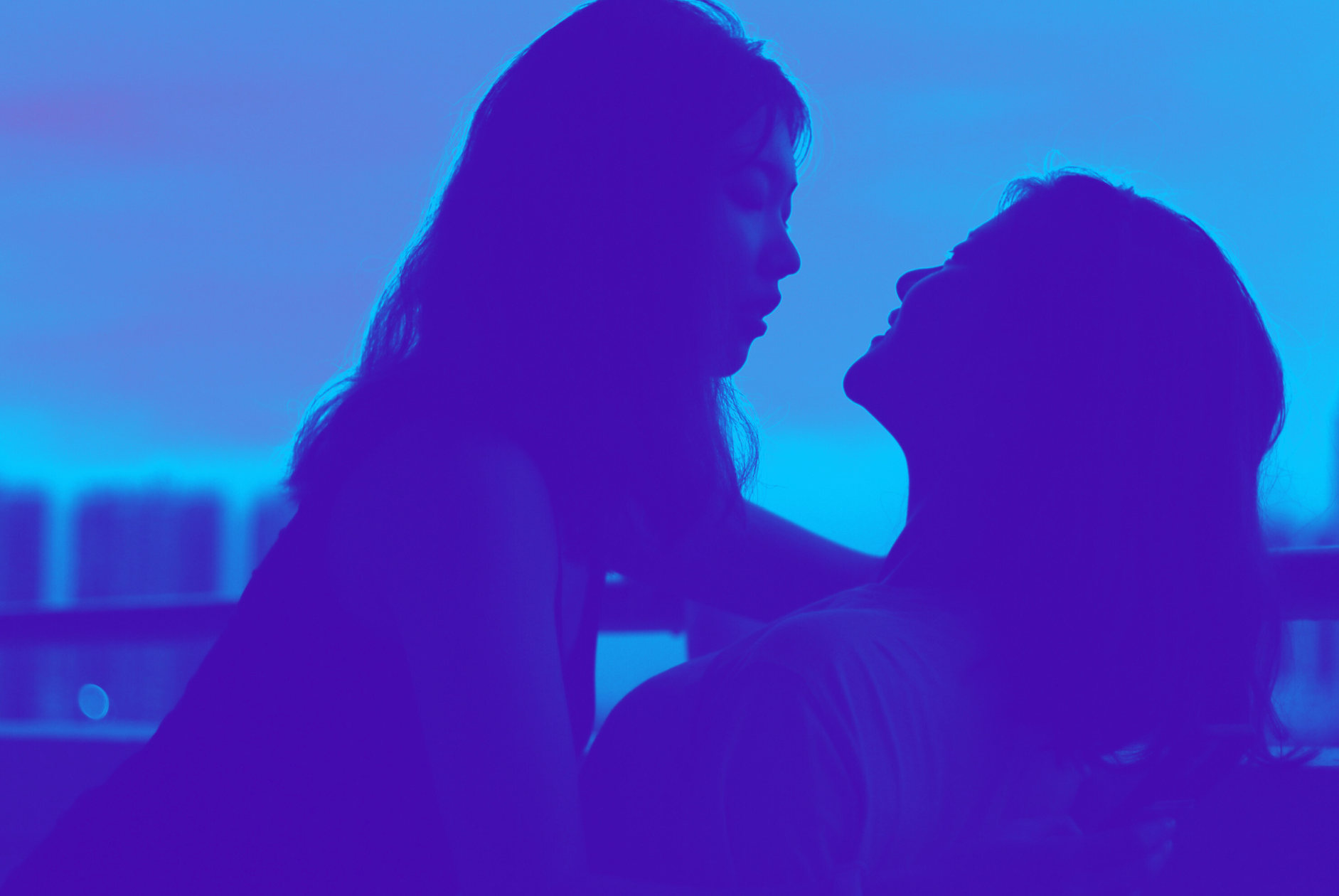 silhouette of women intimately together