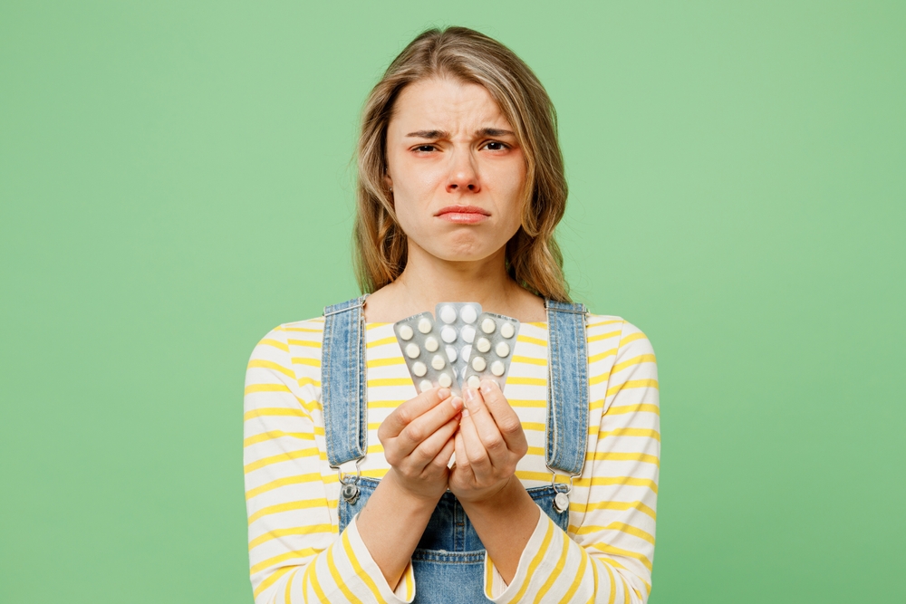 Woman holding up foil packets of white Percocet pills