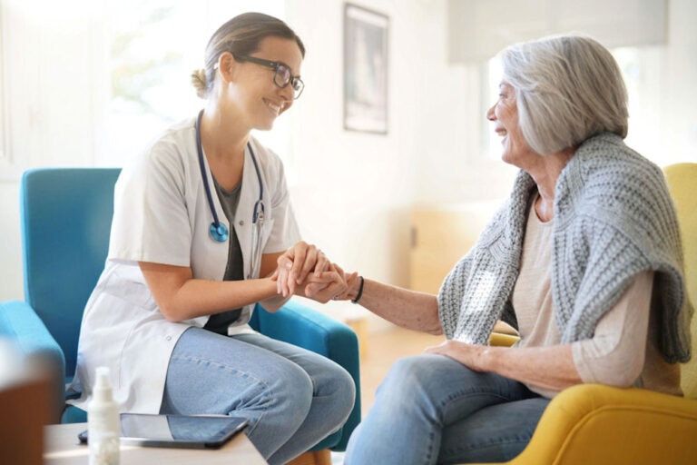 Doctor reassuring older woman going through addiction recovery