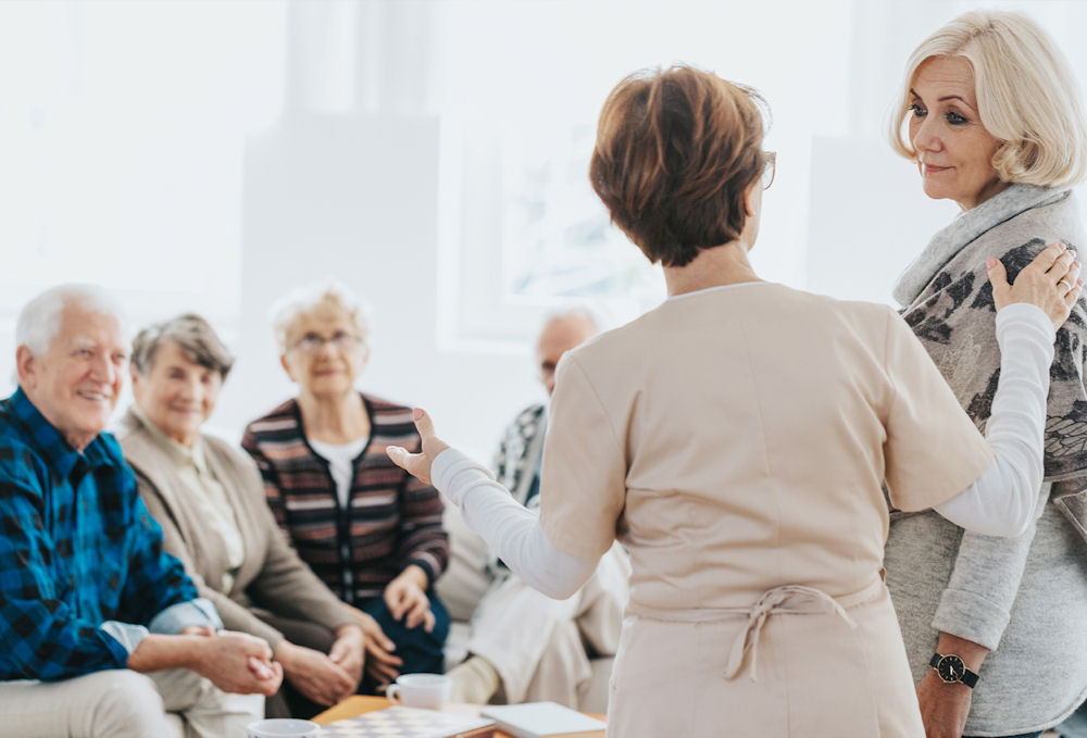 Woman introducing woman to addiction support group for addiction in the elderly